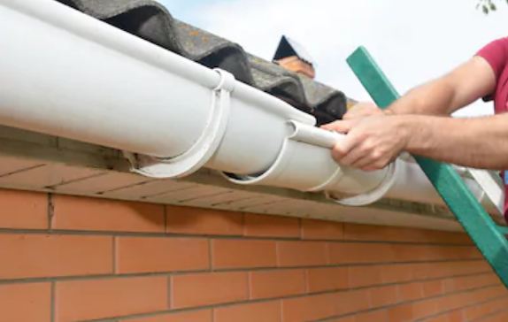Rain flowing through clean guttering and downpipe